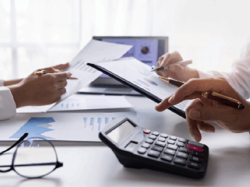 People analyzing financial documents with calculator.