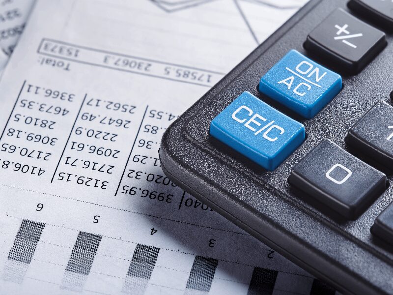 Calculator on financial spreadsheet with graphs.