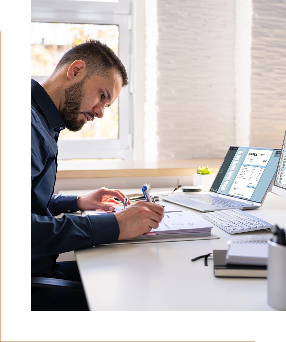 Man working at a desk with laptop.