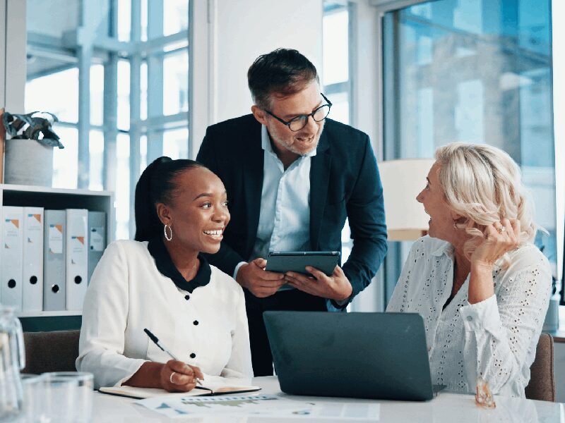 Three colleagues discussing work in an office.
