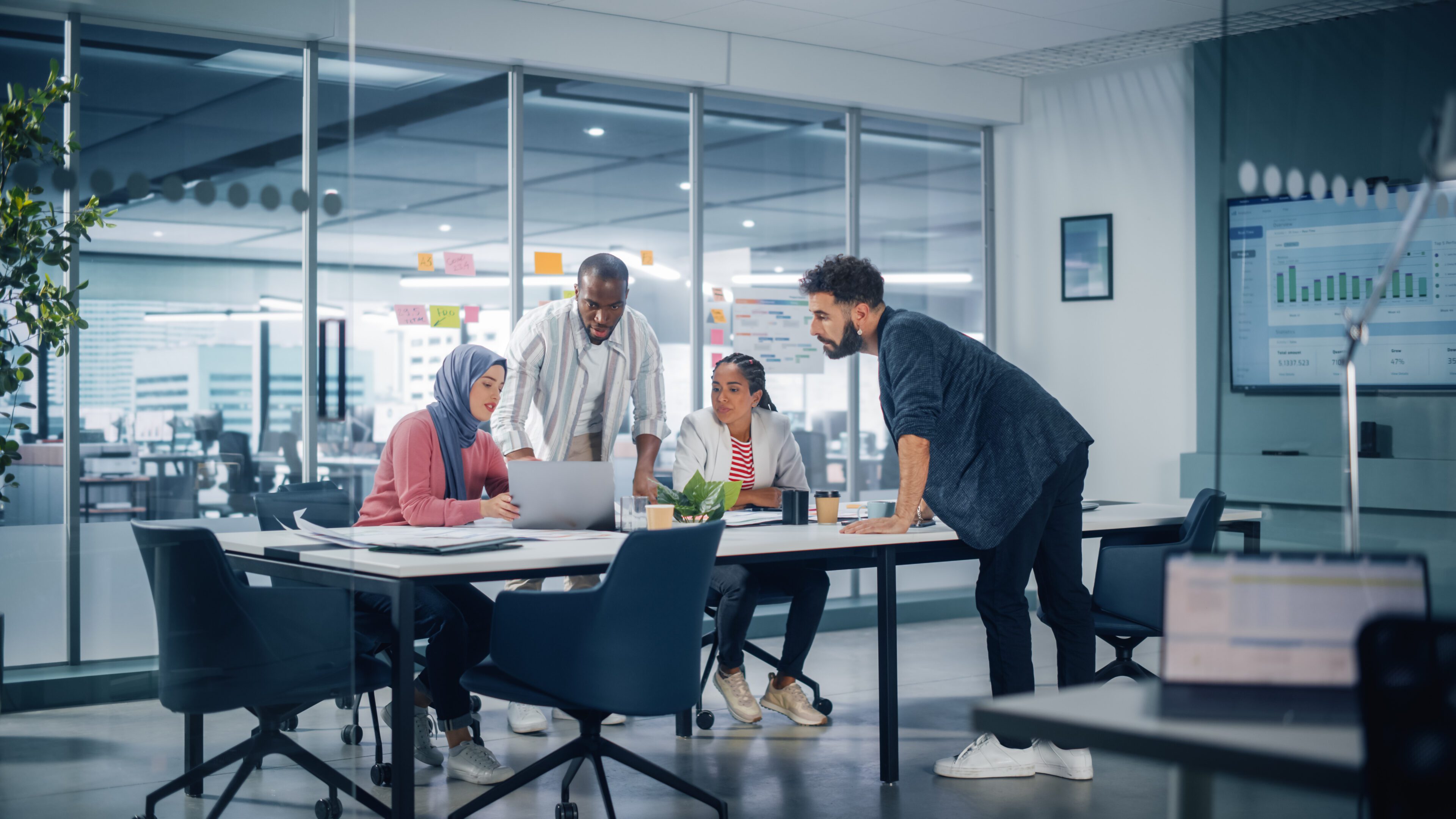 Multi-Ethnic Office Conference Room Meeting: Multicultural Team of Four Creative Entrepreneurs Talk, Discuss Growth Strategy. Diverse Young Businesspeople work on Digital e-Commerce Startup.